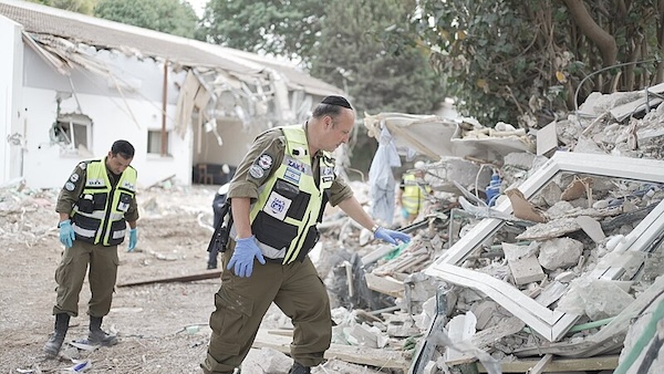 photo - Members of ZAKA identification, extraction and rescue team search through the destruction in a Gaza Envelope community following the Oct. 7 attacks