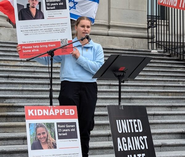 photo - UBC student Zara Nybo, a non-Jewish ally, holds a poster of Rom Braslavski, as she speaks of his heroism before he was taken hostage to Gaza on Oct. 7